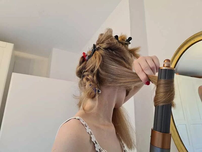 Woman easily styling her hair with the Dyson Airwrap.